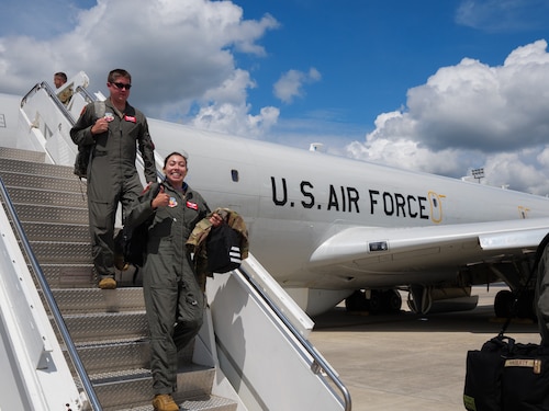 Photo shows Airmen walking down stairs from an aircraft