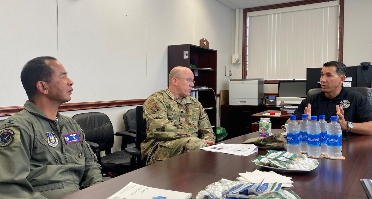 Congressman Kaiali'i Kahele talks with Lt. Col. Shane Lynch and Col. Edward Johnson around conference table at 624 RSG headquarters.