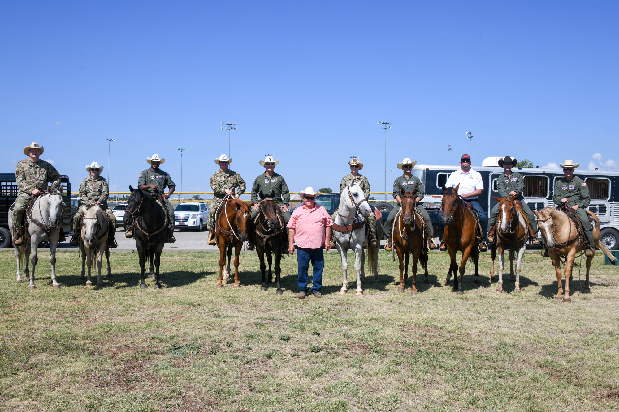 Gary “Bull” Watkins, a friend of Altus since 2011 and rancher (center), poses with the 97th Air Mobility Wing command team, as well as group commanders and senior enlisted leaders (SEL), at the 23rd Annual Cattle Drive at Altus Air Force Base, Oklahoma, Aug. 25, 2022. Watkins has enabled each cattle drive, where he fits each commander and SEL to their horses. (U.S. Air Force photo by Senior Airman Trenton Jancze)