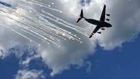 A C-17 Globemaster III aircraft from the 305th Air Mobility Wing, and its associate reserve unit the 514th Air Mobility Wing, based at Joint Base McGuire-Dix-Lakehurst, New Jersey,  practices flying a resupply mission with a low-level ingress into a hostile location while responding to simulated surface to air missiles fired by an enemy at Bollen Range on Fort Indiantown Gap, Pennsylvania, Aug. 22, 2002. The crew of the C-17 included two 111th Attack Wing personnel, who assisted in integrating MQ-9 support including real time intelligence updates and armed over watch, in addition to identification and clearance of any threats present during the mission. The C-17 also practiced performing defensive maneuvers that included dispensing flares. (U.S. Air National Guard photo by Jon Dahms)