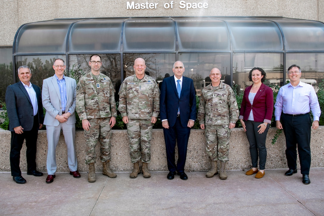 A group of military members and civilians pose for a group photo