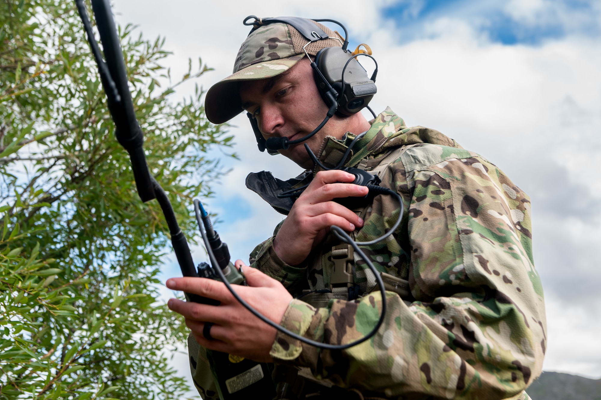 An Airman works a handheld radio transmitter.