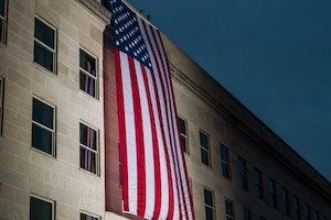 A Pentagon crew unfurls an American flag at dawn at the Pentagon, on the anniversary of the 9/11 attacks, Washington, D.C.. (DoD photo by U.S. Army Staff Sgt. Nicole Mejia)