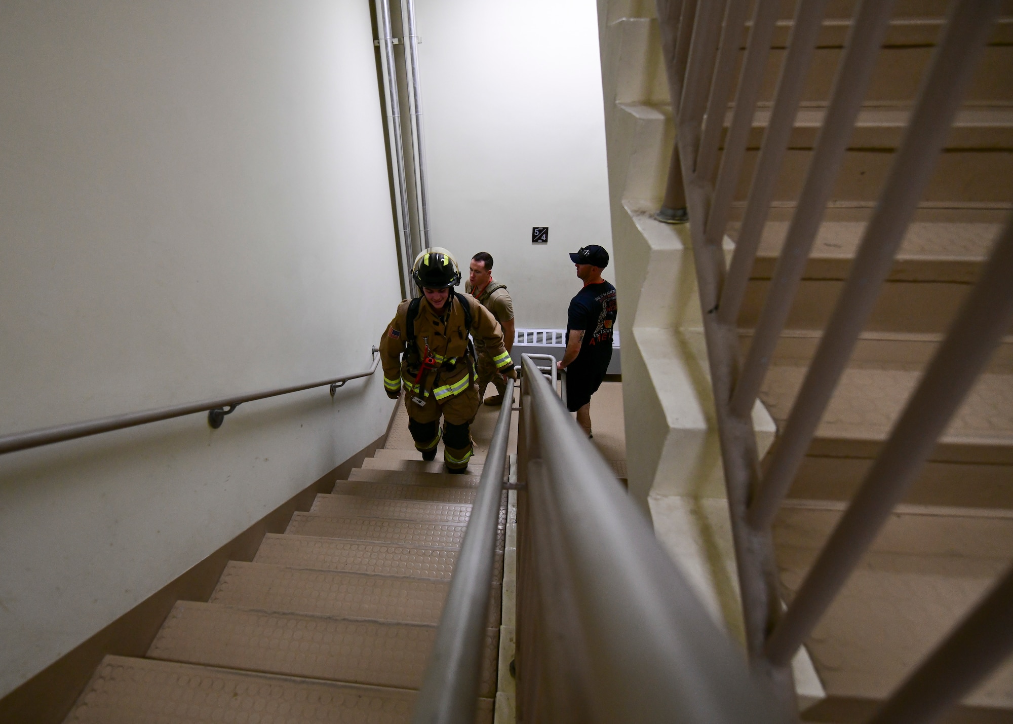 Military firefighters climb stairs