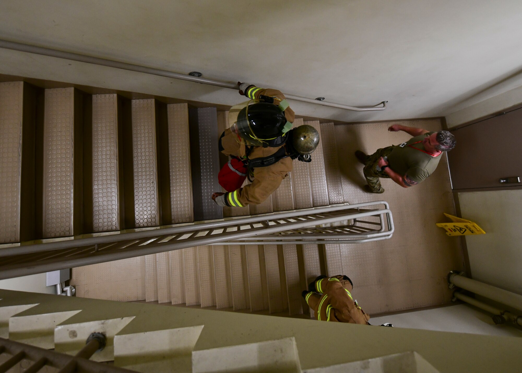Military firefighters climb stairs