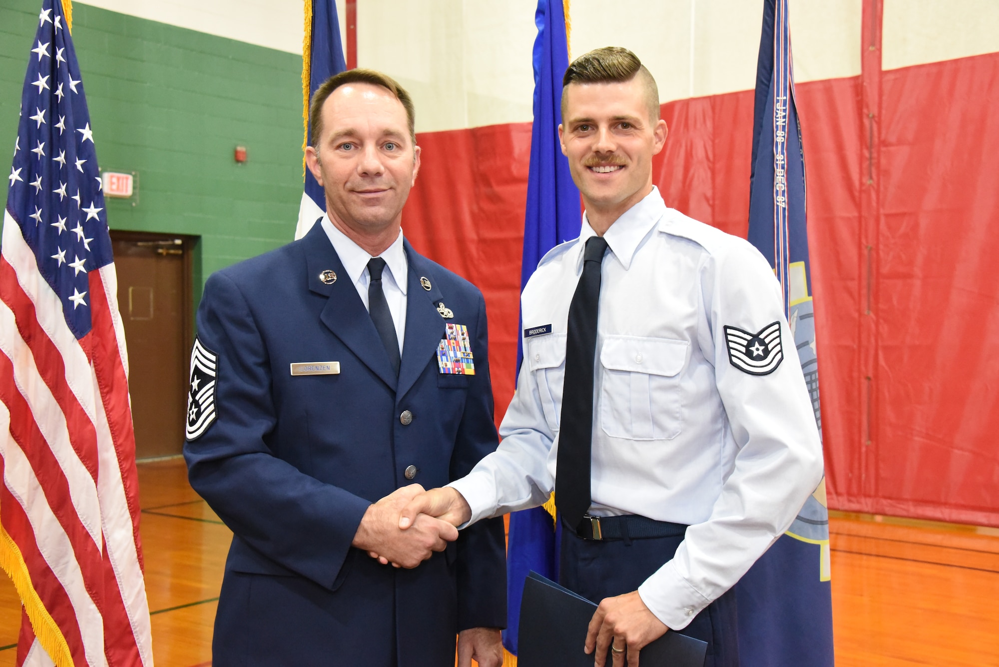 Master Sgt. Dakota Broderick shakes hands with Command Chief Master Sgt. Ronald Lorenzen