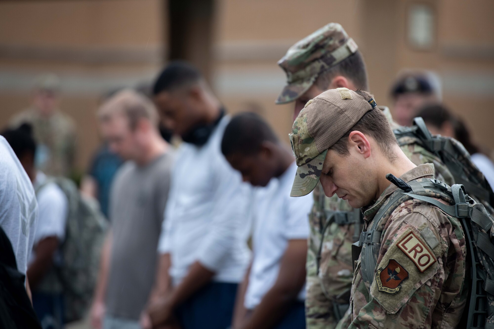 A group of Airmen and civilians bow their heads to pay respects to the Prisoners of War and Missing in Action men and women, at Maxwell Air Force Base, September 9, 2022. The march consisted of several stops to honor the fallen.