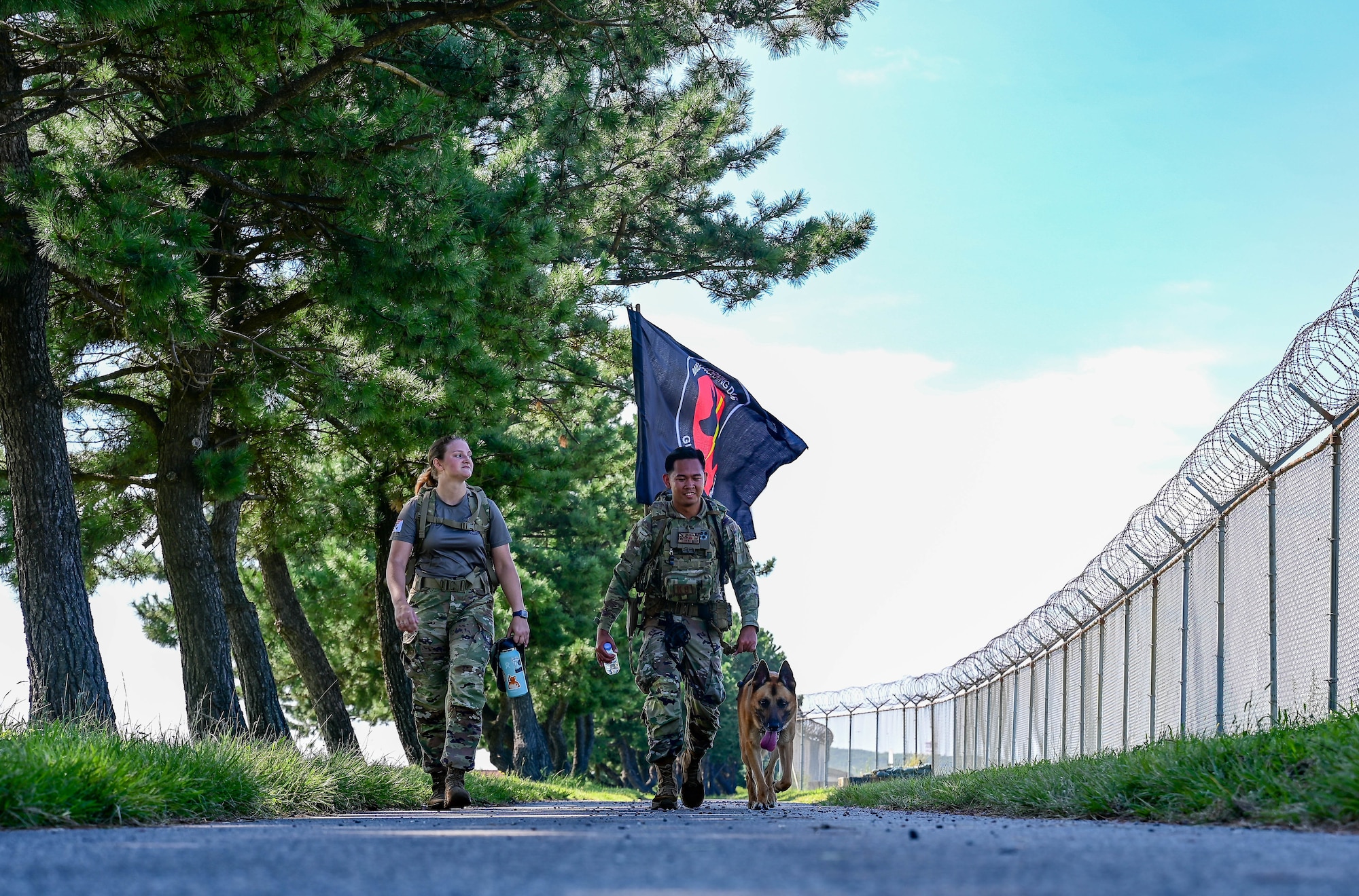 Senior Airman Jonathan Casazza Barbosa, 8th Security Forces Squadron military working dog handler, walks with the military working dog flag during a 9/11 remembrance ceremony at Kunsan Air Base, Republic of Korea, Sept. 8, 2022. Over 300 dogs assisted the search and rescue efforts after the terrorist attacks on Sept. 11, 2001. (U.S. Air Force photo by Senior Airman Shannon Braaten)