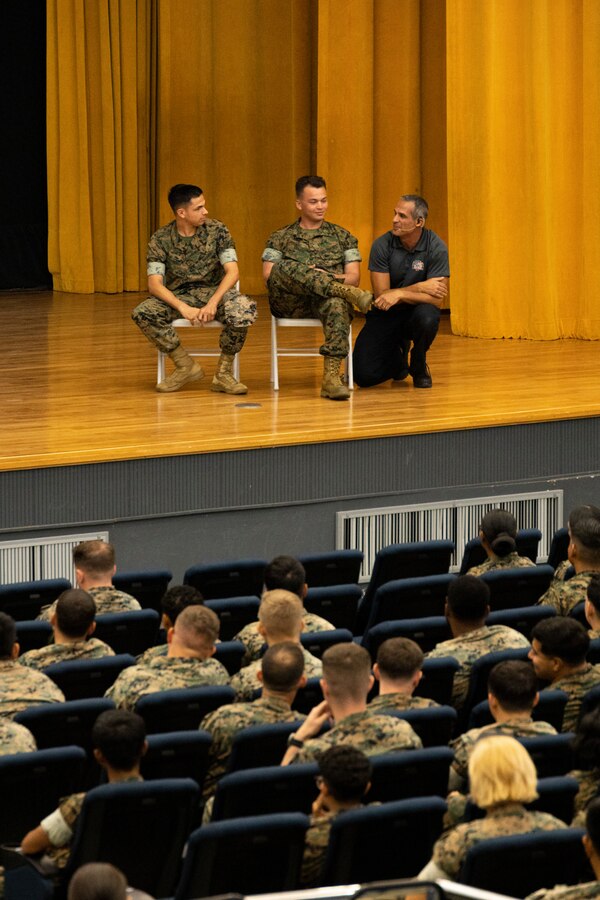 Oscar Duran, a firefighter paramedic and Stay Alive from Education presenter discusses a car accident scenario using Marines from the audience as volunteers during a “Street Smart” presentation at the Camp Foster theater, Okinawa, Japan, Sept. 1, 2022. U.S. Marines Lance Cpl. Garrett Perry and Cpl. Jerryn Couch, attendees with Headquarters and Support Battalion, Marine Corps Installations Pacific, answered questions from Duran and performed as visual aids for the interactive workshop. Presenters with Stay Alive from Education provided “StreetSmart” training to Marines to raise awareness of the consequences of unsafe driving. The SAFE team is a group of firefighters and paramedics that performed an interactive presentation to educate audiences on car accident scenarios. (U.S. Marine Corps photo by Lance Cpl. Thomas Sheng)