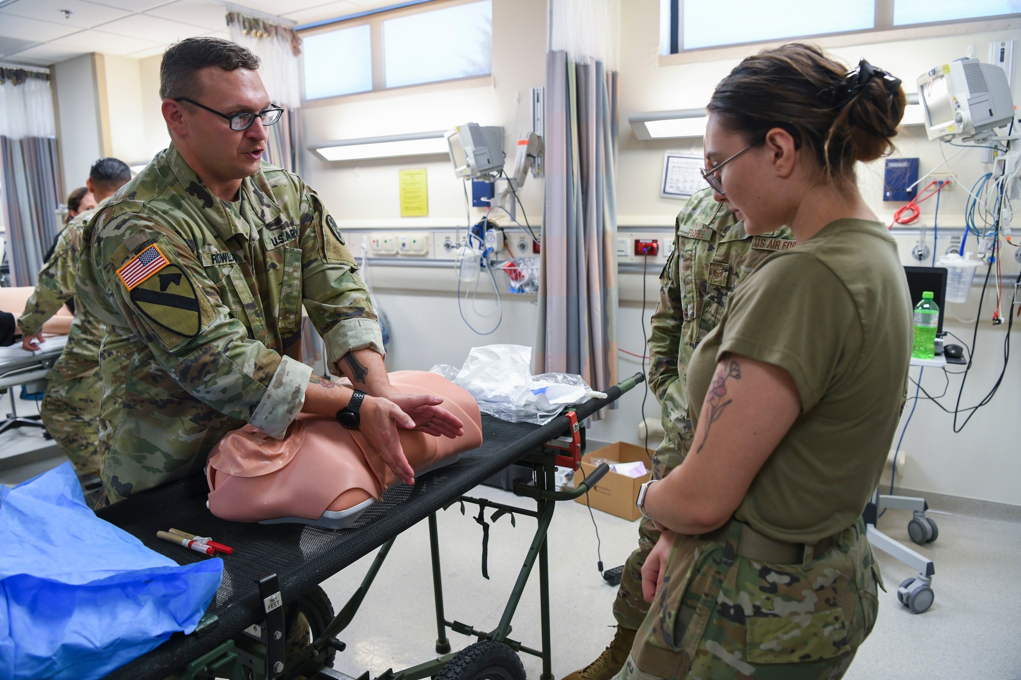 U.S. Army Sgt. 1st Class Bryan Rowland, U.S. Army Medical Department Activity Bavaria NCOIC of education and training, left, teaches A1C Justice Nerad, 31st Health Care Operations Squadron aerospace medical technician, right, how to treat a collapsed lung using a training mannequin