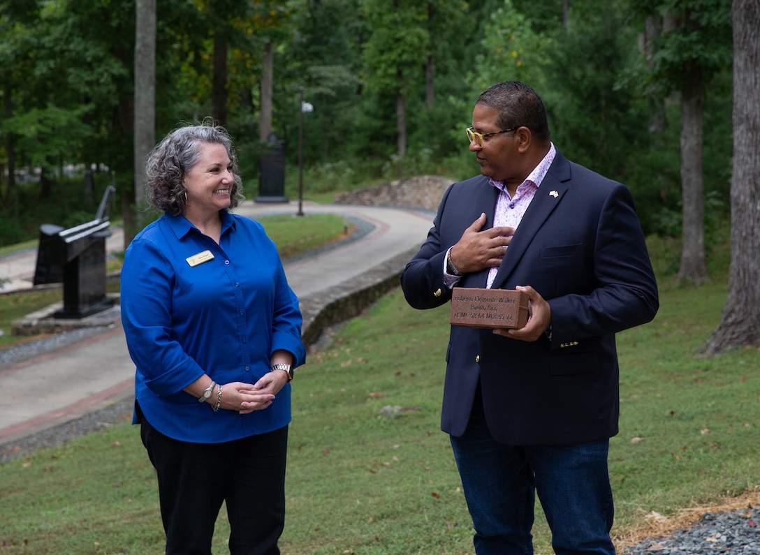 Sara Hogan, senior development manager, Marine Corps Heritage Foundation, joins Luis R. Clemente in a brick laying ceremony at the National Museum of the Marine Corps in Triangle, Virginia, Sept. 7, 2022. The ceremony was held to commemorate Luis’ father, Roberto Clemente, Major League Baseball Hall of Famer and U.S. Marine. (US Marine Corps photo by Lance Cpl. Kayla LeClaire)