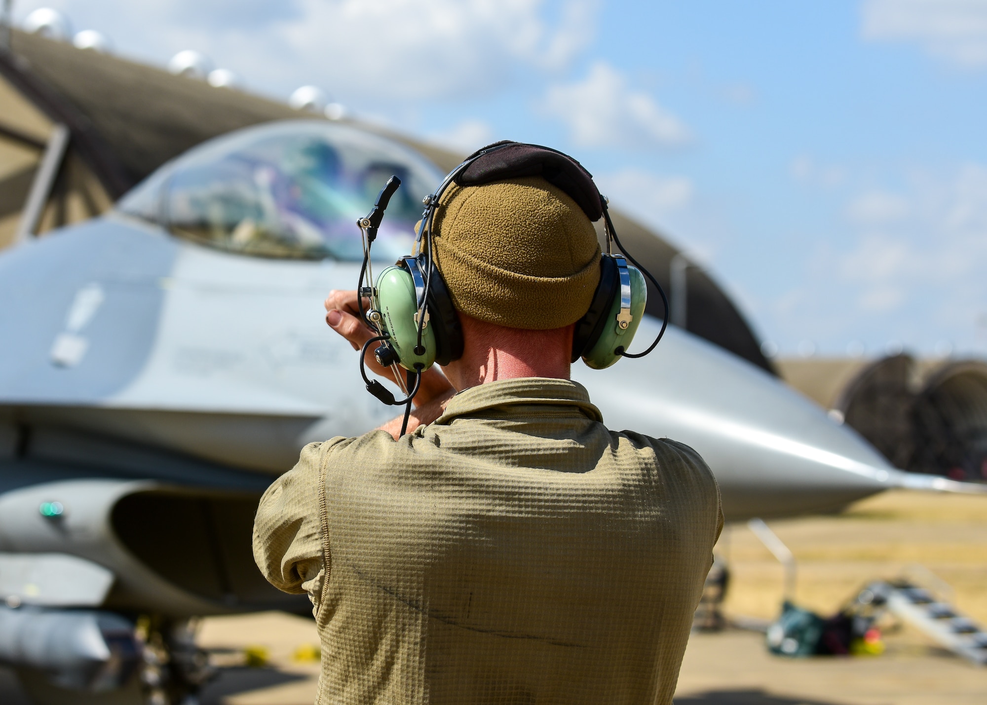 Airman 1st Class Michael Schutzius, 555th Fighter Generation Squadron crew chief from the 31st Fighter Wing, Aviano Air Base, Italy, signals an F-16C Fighting Falcon pilot, prior to take-off, during pre-exercise training for Cobra Warrior 2022