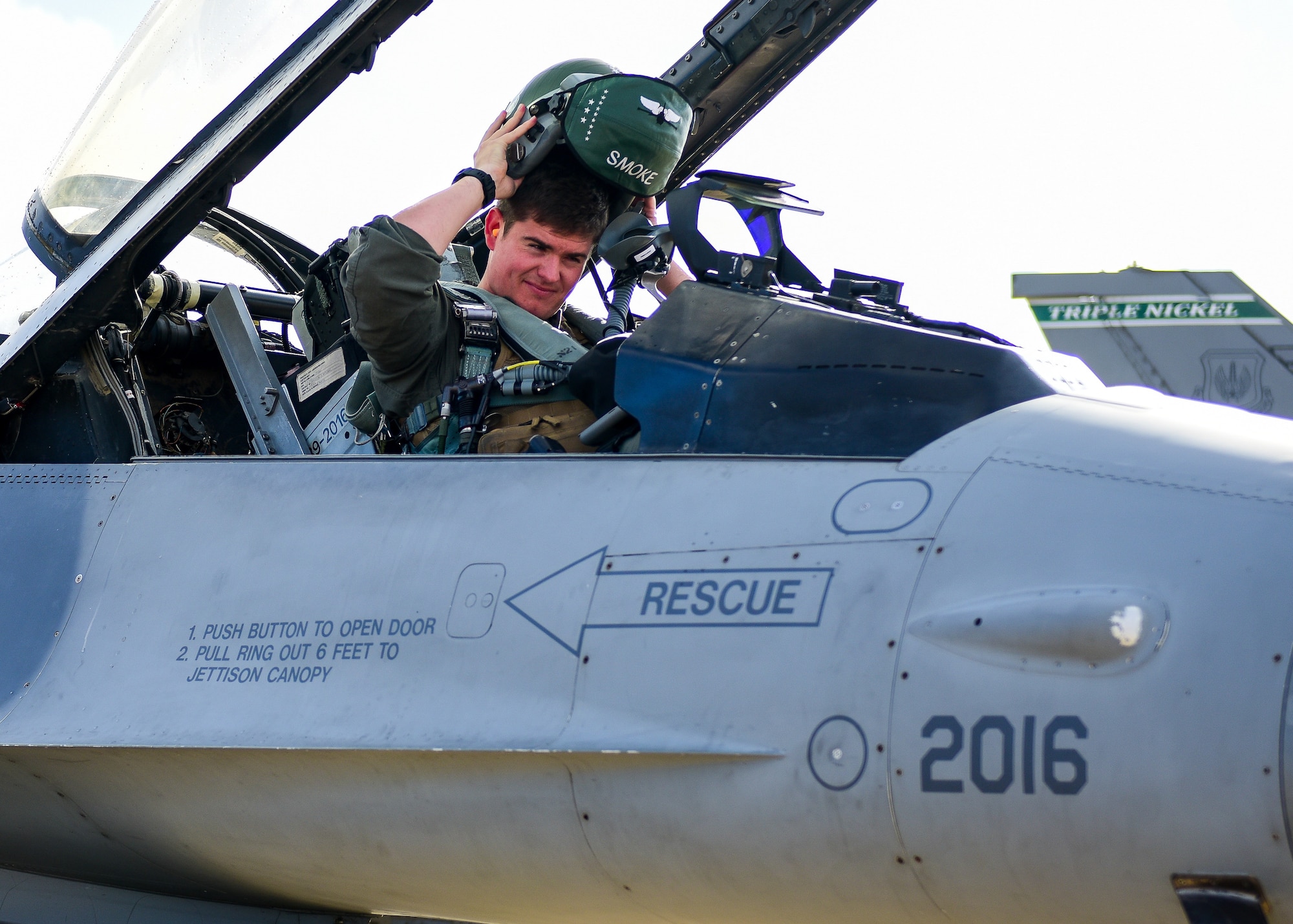 U.S. Air Force Capt. McCall Kerkman, 555th Fighter Squadron F-16C Fighting Falcon pilot from the 31st Fighter Wing, Aviano Air Base, Italy, places his flight helmet on before taxiing his aircraft