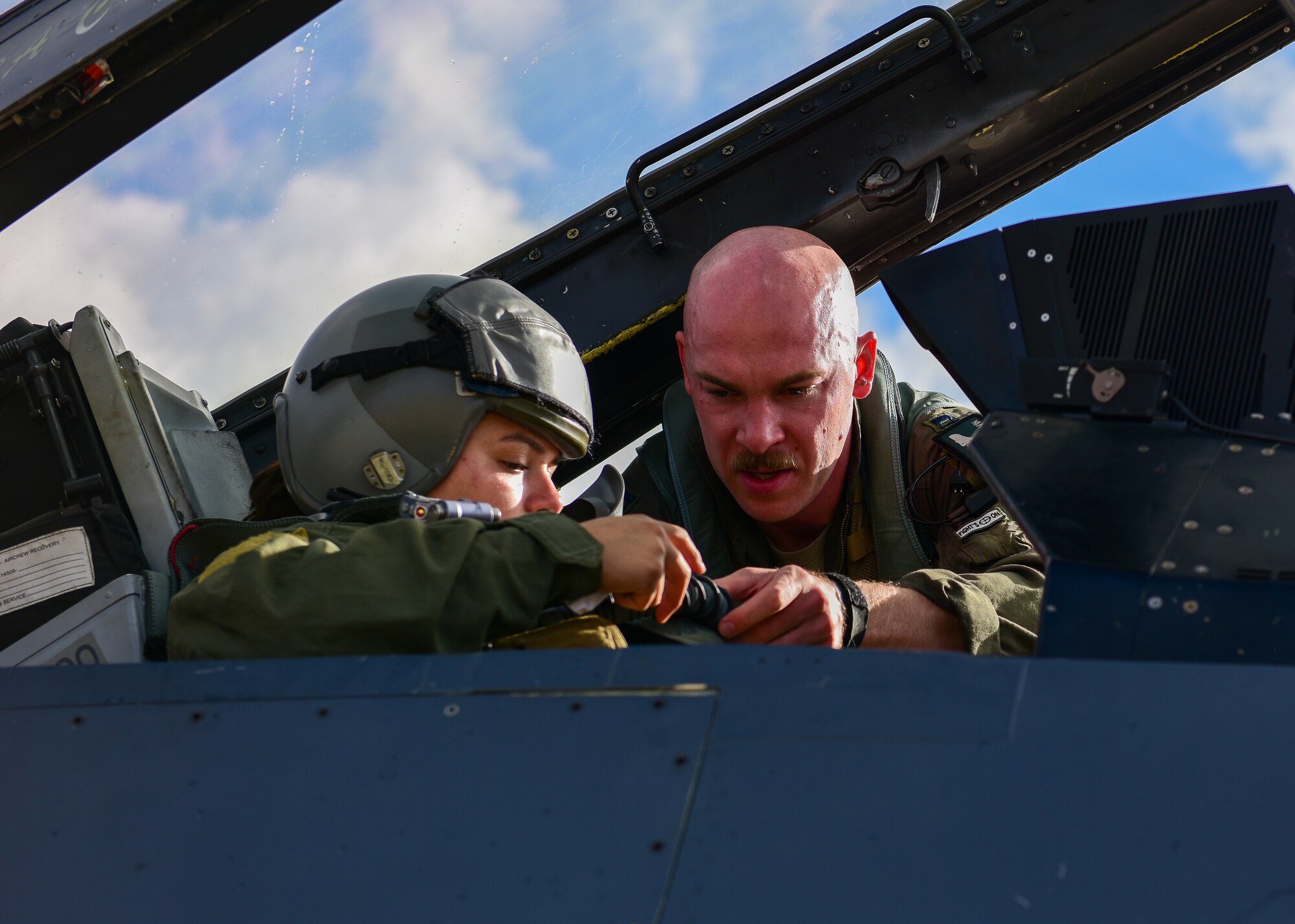 U.S. Air Force Capt. Michael Kelvin, 555th Fighter Squadron F-16C Fighting Falcon pilot fastens the seat of Senior Airman Sierra Glassburner, 555th Fighter Squadron independent duty medical technician, both from the 31st Fighter Wing, Aviano Air Base, Italy, before taking flight