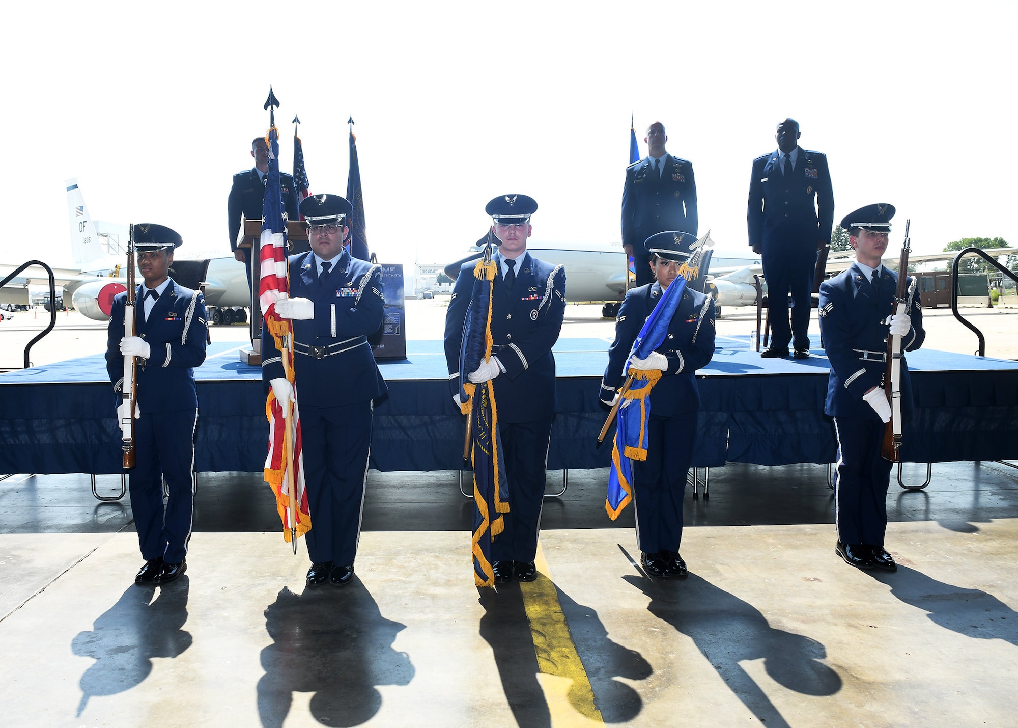Air Force Airmen carry flags during a ceremony
