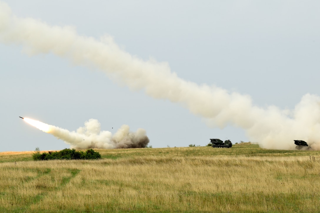 Soldiers fire rockets through the air.