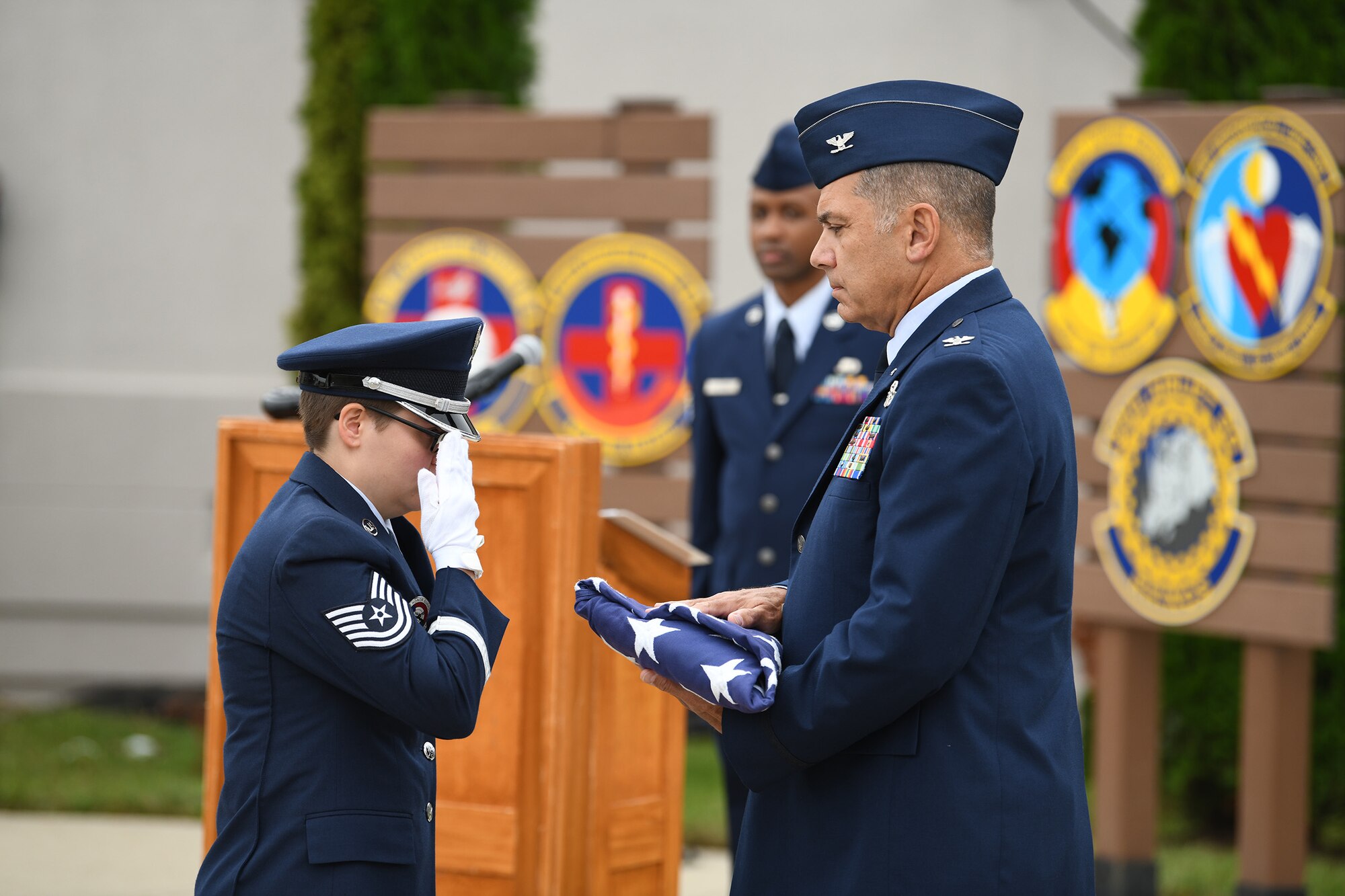 Tech. Sgt. Molly Cook, Wright-Patterson Air Force Base Honor Guard member, presents a flag to Col. Raymond Smith Jr., during the 445th Airlift Wing 9/11 remembrance ceremony Sept. 11, 2022.