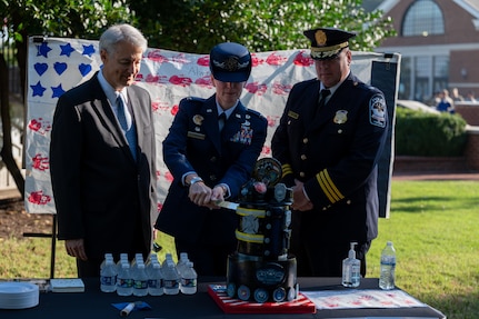 Col. Catherine Logan, JBAB and 11th Wing commander, cuts a cake decorated for the first responders, Pentagon and U.S. military branches with Robert Cooper, Chief of Pentagon Services, and William Lagasse, Deputy Chief of the Pentagon Force Protection Agency, after the 9/11 Remembrance Ceremony at Joint Base Anacostia-Bolling, Washington, D.C., Sept. 9, 2022. The annual event is held in honor of those who lost their lives during the terrorist attacks at the World Trade Center and Pentagon on Sept. 11, 2001, and in remembrance of those who responded. (U.S. Air Force photo by Kristen Wong)