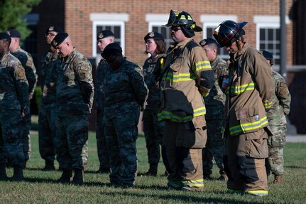 Members of the 11th Security Forces Squadron and Naval District of Washington Fire Department bow their heads during a moment of silence during the 9/11 Remembrance Ceremony at Joint Base Anacostia-Bolling, Washington, D.C., Sept. 9, 2022. The annual event is held in honor of those who lost their lives during the terrorist attacks at the World Trade Center and Pentagon on Sept. 11, 2001, and in remembrance of those who responded. (U.S. Air Force photo by Kristen Wong)