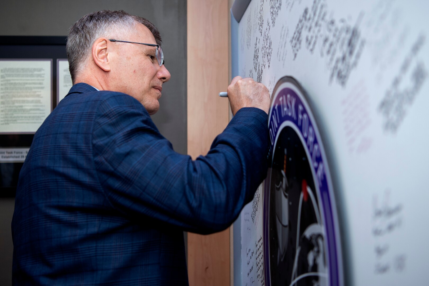 Man in suit signing board