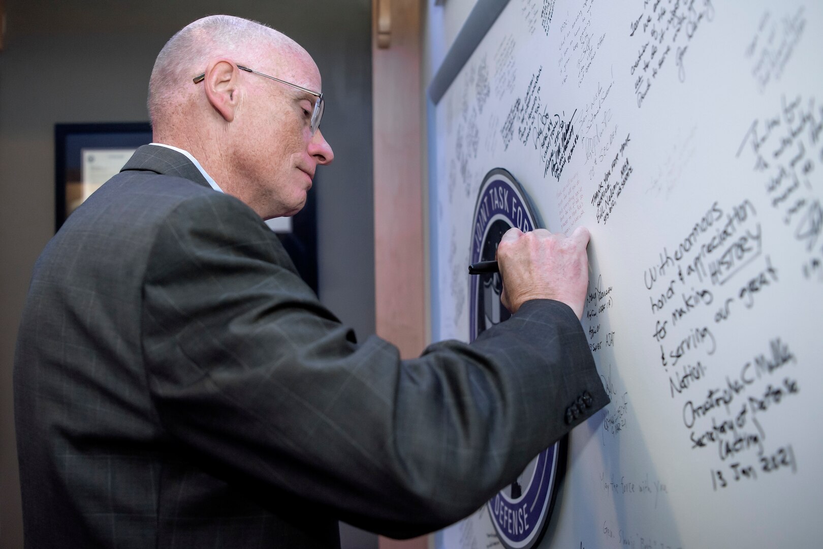 Man in suit signing board