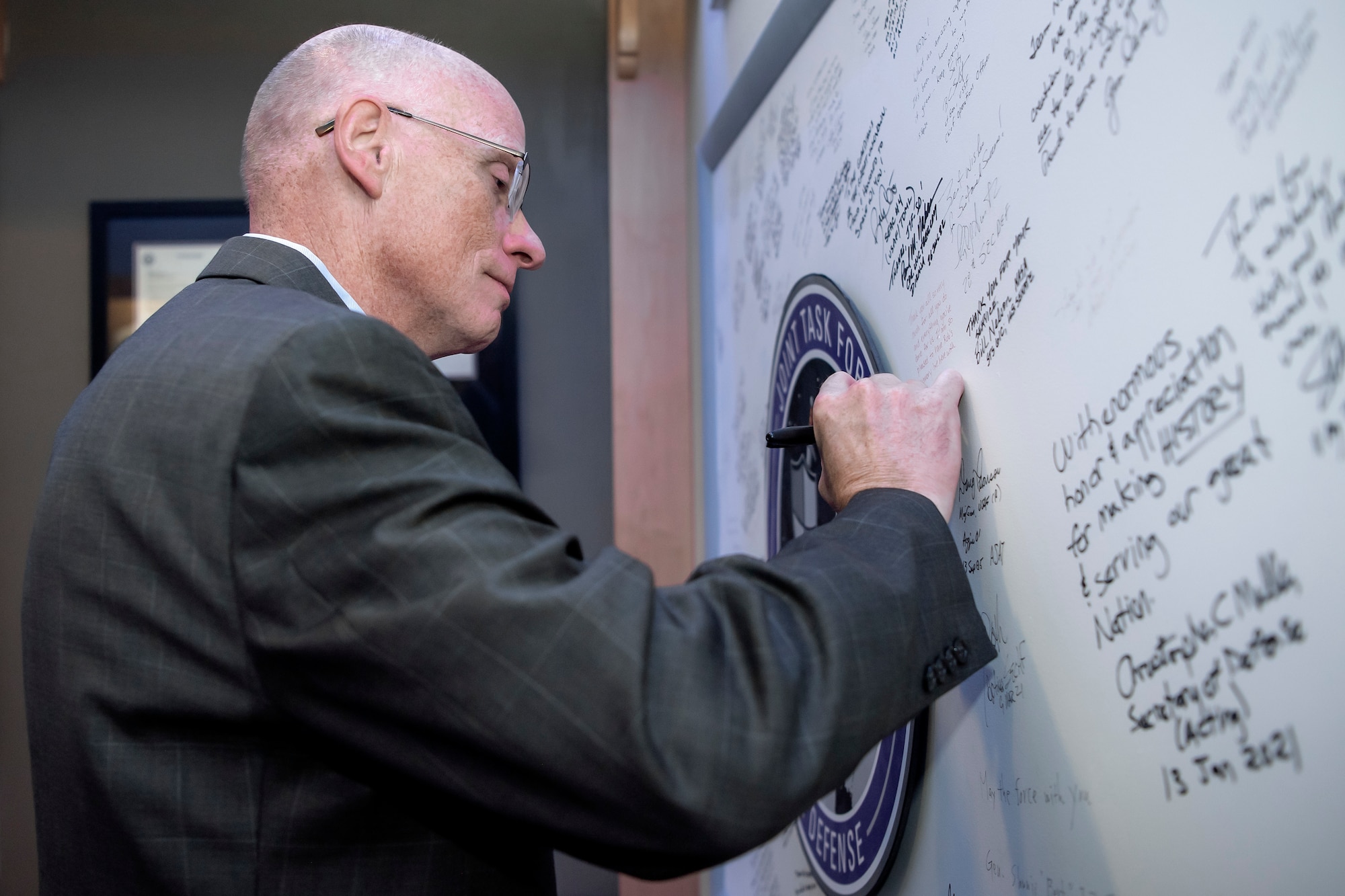Man in suit signing board