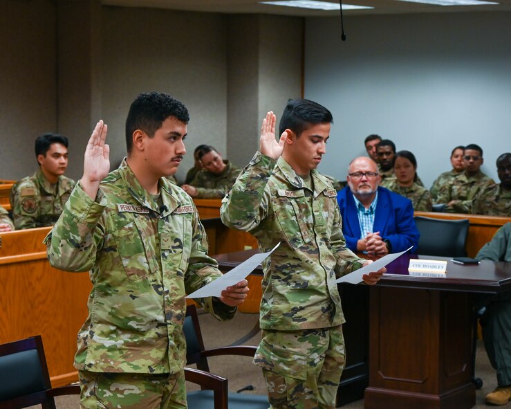 Airman Amin Ahmadi, a 5th Logistics Readiness Squadron traffic management office apprentice, and Airman 1st Class Jorge Peralta, a 5th Force Support Squadron classification technician, recite the Naturalization Oath of Allegiance to the United States of America at Minot Air Force Base, N.D., Aug. 31, 2022. Ahmadi and Peralta participated in the first naturalization ceremony held at Minot Air Force Base. For more than 200 years the oath has been recited by many Americans on their pathway to citizenship.  (U.S. Air Force photo by Senior Airman Evan Lichtenhan)