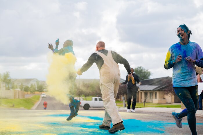 Kirk Clark, center, 341st Operational Medical Readiness Squadron health promotion coordinator, throws colored powder on Capt. Dominic Smyth, 341st Missile Wing chaplain, while Capt. Raquel Lewis, 341st OMRS public health flight commander, crosses the finish line during a Suicide Awareness Color Run Sept. 9, 2022, at Malmstrom Air Force Base, Mont.