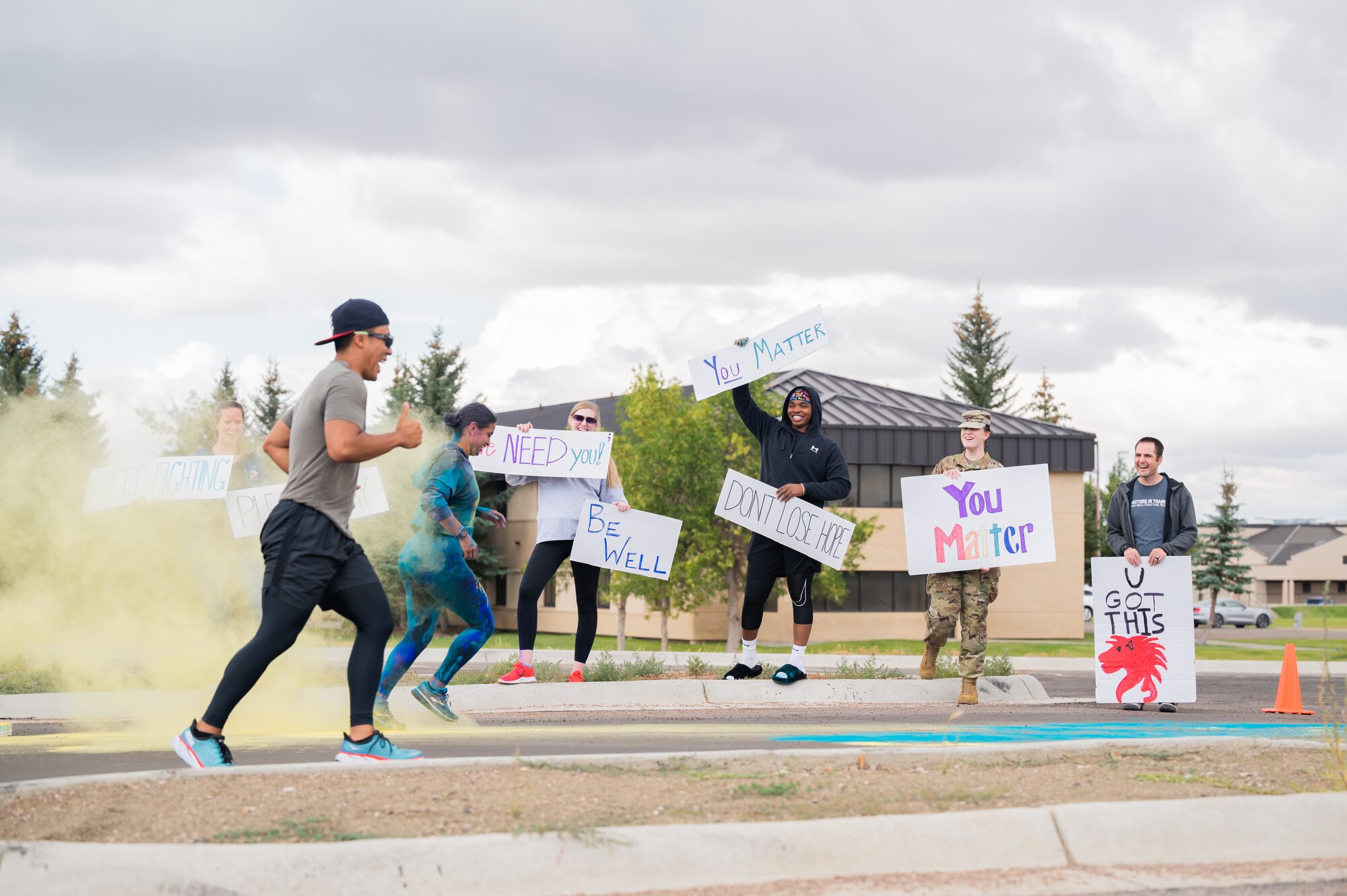 Members of the 341st Missile Wing cross the finish line while others hold signs of encouragement during a Suicide Awareness Color Run Sept. 9, 2022, at Malmstrom Air Force Base, Mont.