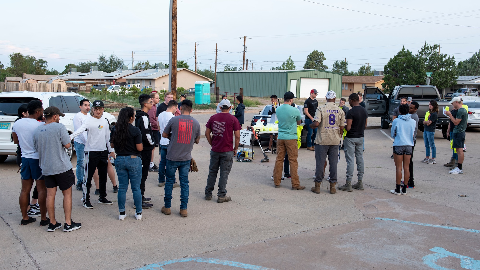 A crowd of people stand in a parking lot.