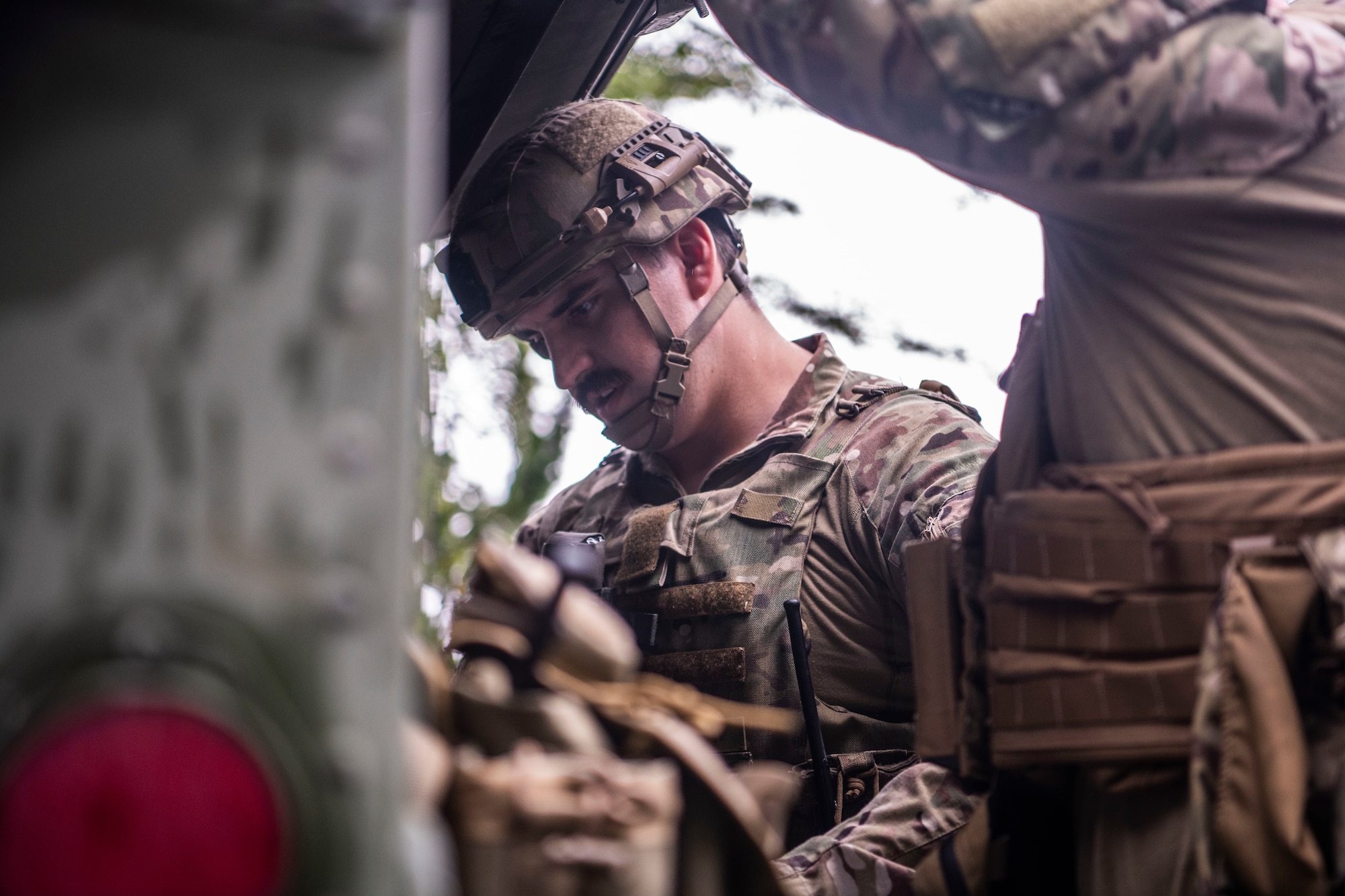 A U.S. Air Force member looks at equipment in the trunk of a Humvee.