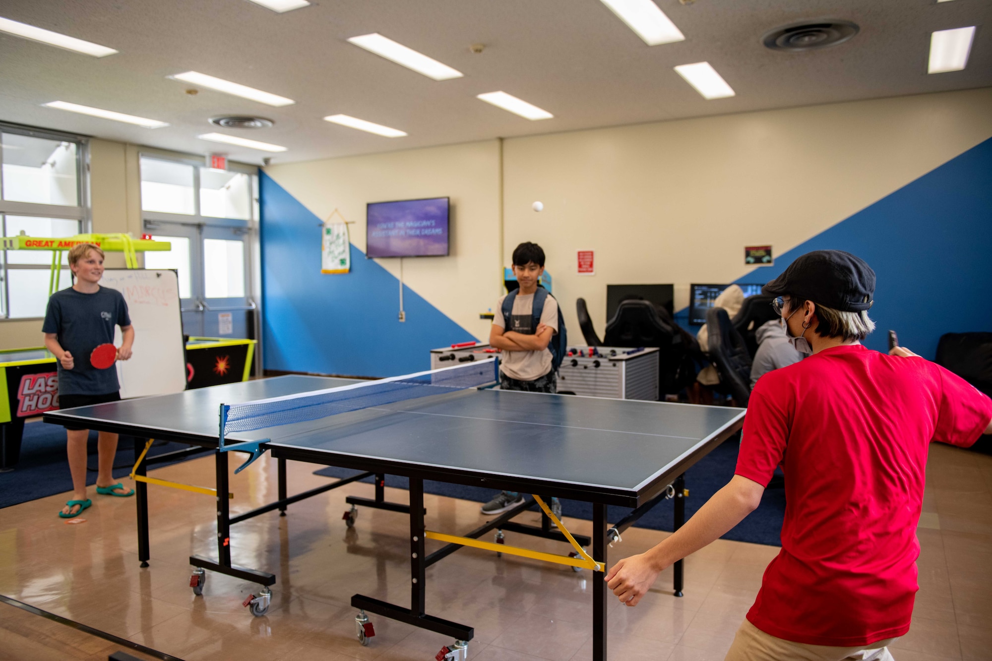 A Japanese teenager plays ping pong with children