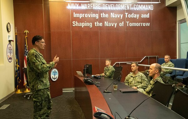 Maritime Operations Center Director Capt. Patrick Newbrough, commanding officer, U.S. Naval Forces Central Command consults with the operational planning team to discuss challenges and responses to events occurring during a maritime operations center exercise in Norfolk. The maritime operations center exercise, comprised of 10 units, is a training exercise by Reserve Sailors, for Reserve Sailors to strategically align with mission requirements to support the fleet in the four lines of effort which are design, train, mobilize and develop. (U.S. Navy photo by Mass Communications Specialist 1st Class Helen Brown)