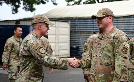 Airman shakes another Airman's hand.