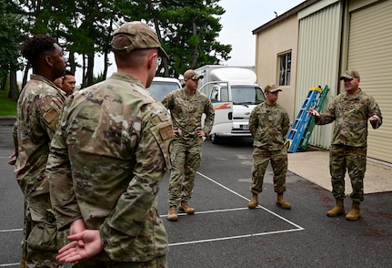 Airman talks to a group of Airmen standing.