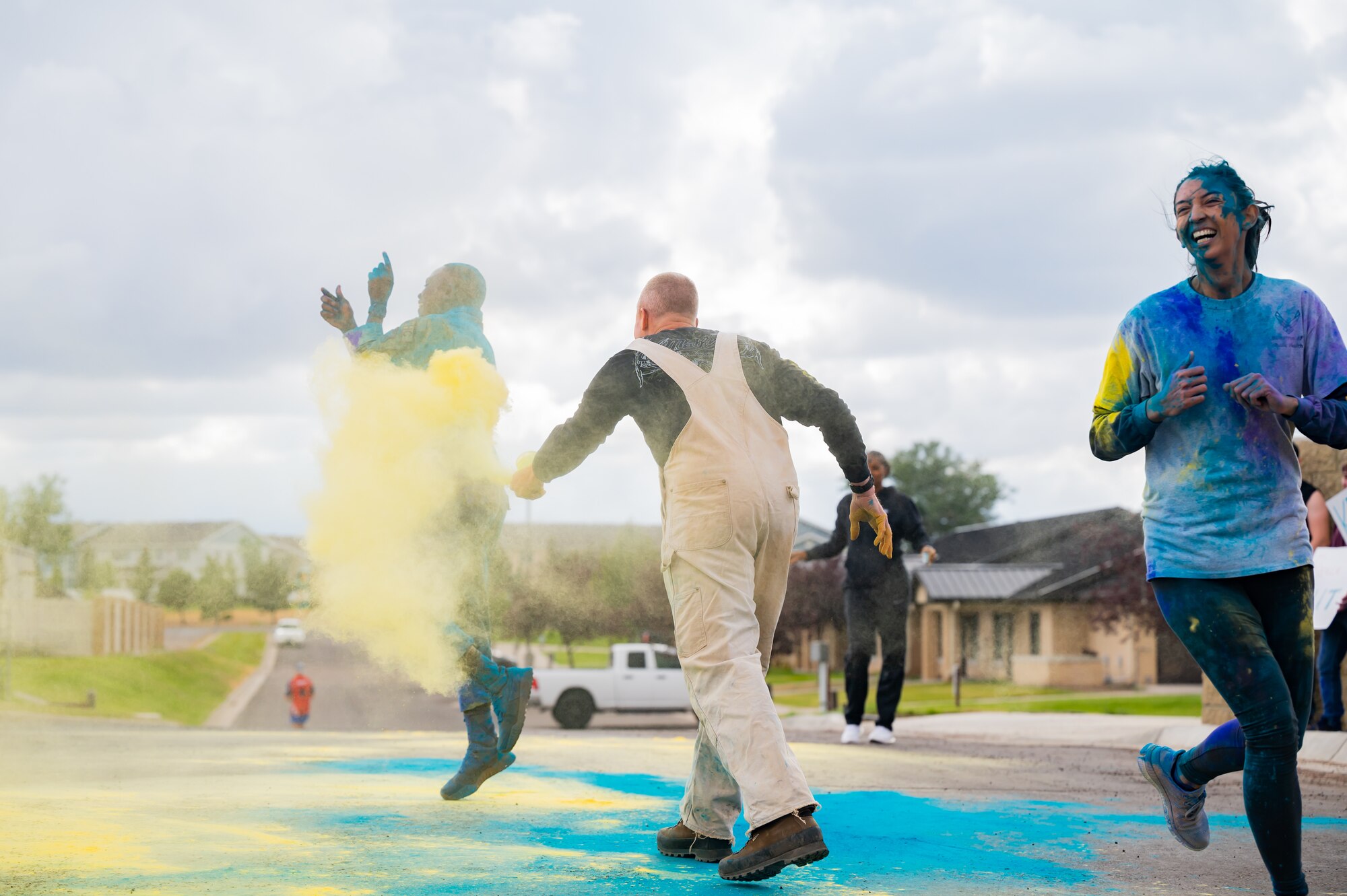Kirk Clark, center, 341st Operational Medical Readiness Squadron health promotion coordinator, throws colored powder on Capt. Dominic Smyth, 341st Missile Wing chaplain, while Capt. Raquel Lewis, 341st OMRS public health flight commander, crosses the finish line during a Suicide Awareness Color Run Sept. 9, 2022, at Malmstrom Air Force Base, Mont.