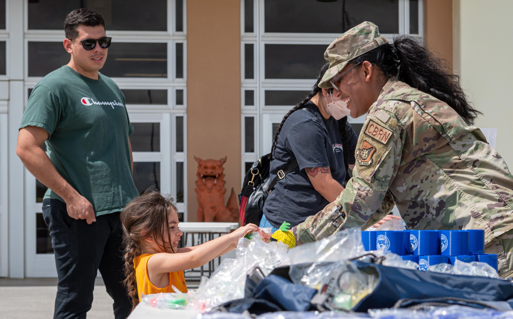 An Airman hands a child a toy