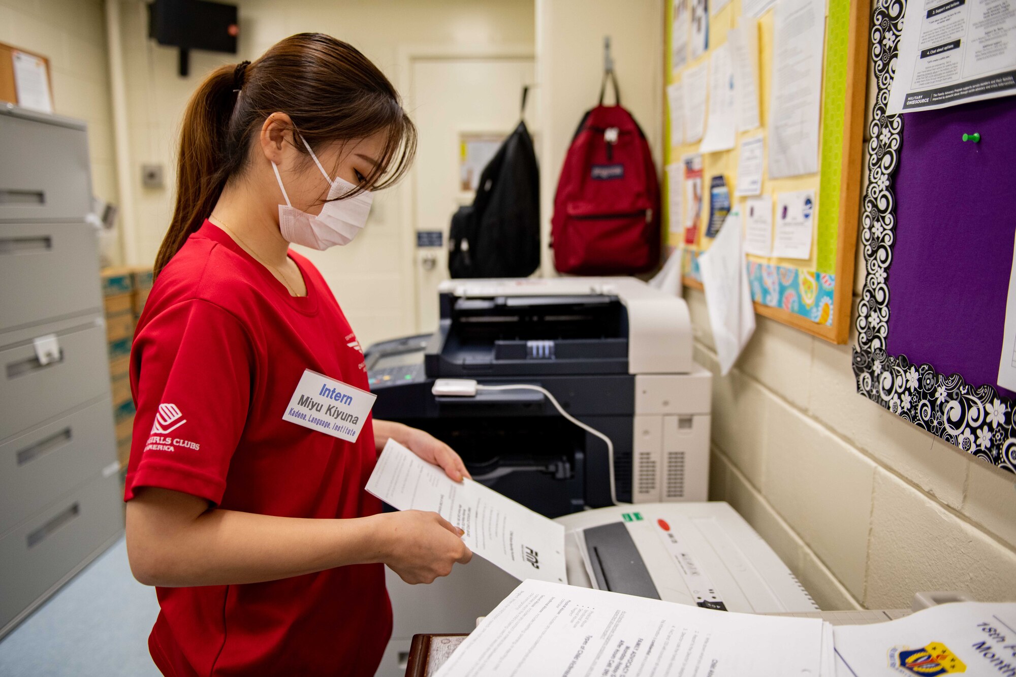 A Japanese girl shreds paper in a back office