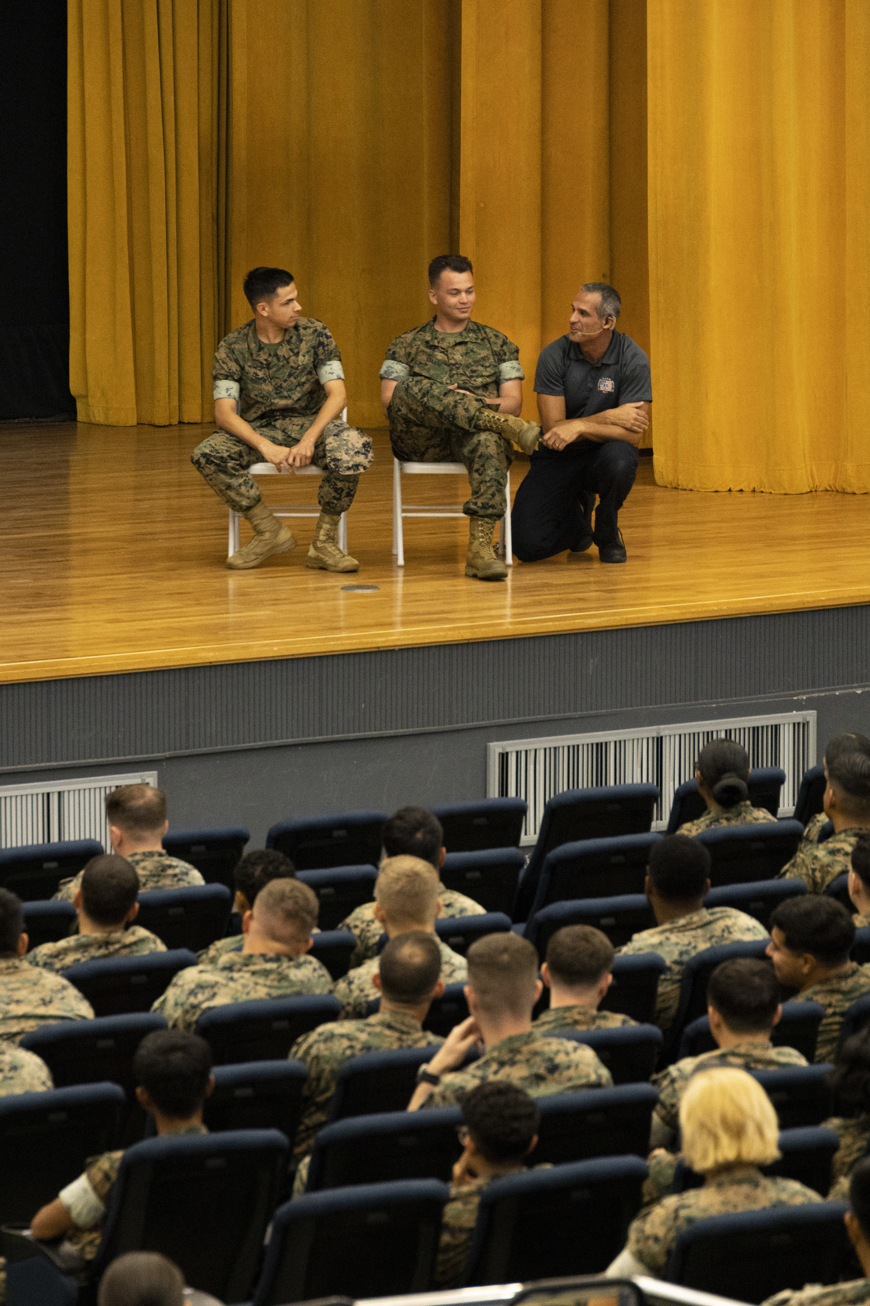 Oscar Duran, a firefighter paramedic and Stay Alive from Education presenter discusses a car accident scenario using Marines from the audience as volunteers during a “Street Smart” presentation at the Camp Foster theater, Okinawa, Japan, Sept. 1, 2022. U.S. Marines Lance Cpl. Garrett Perry and Cpl. Jerryn Couch, attendees with Headquarters and Support Battalion, Marine Corps Installations Pacific, answered questions from Duran and performed as visual aids for the interactive workshop. Presenters with Stay Alive from Education provided “StreetSmart” training to Marines to raise awareness of the consequences of unsafe driving. The SAFE team is a group of firefighters and paramedics that performed an interactive presentation to educate audiences on car accident scenarios. (U.S. Marine Corps photo by Lance Cpl. Thomas Sheng)