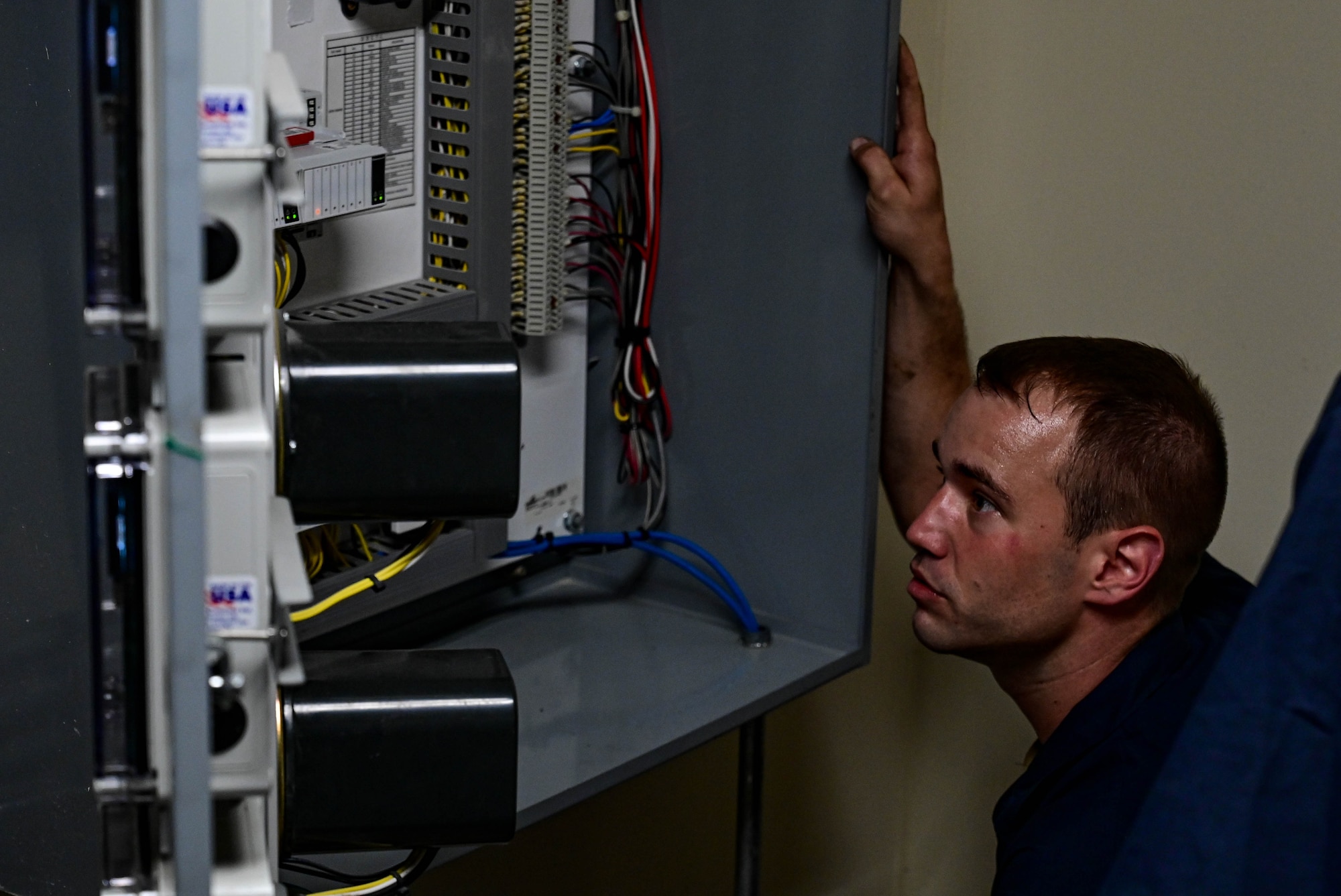 Man looks at electrical pannel.