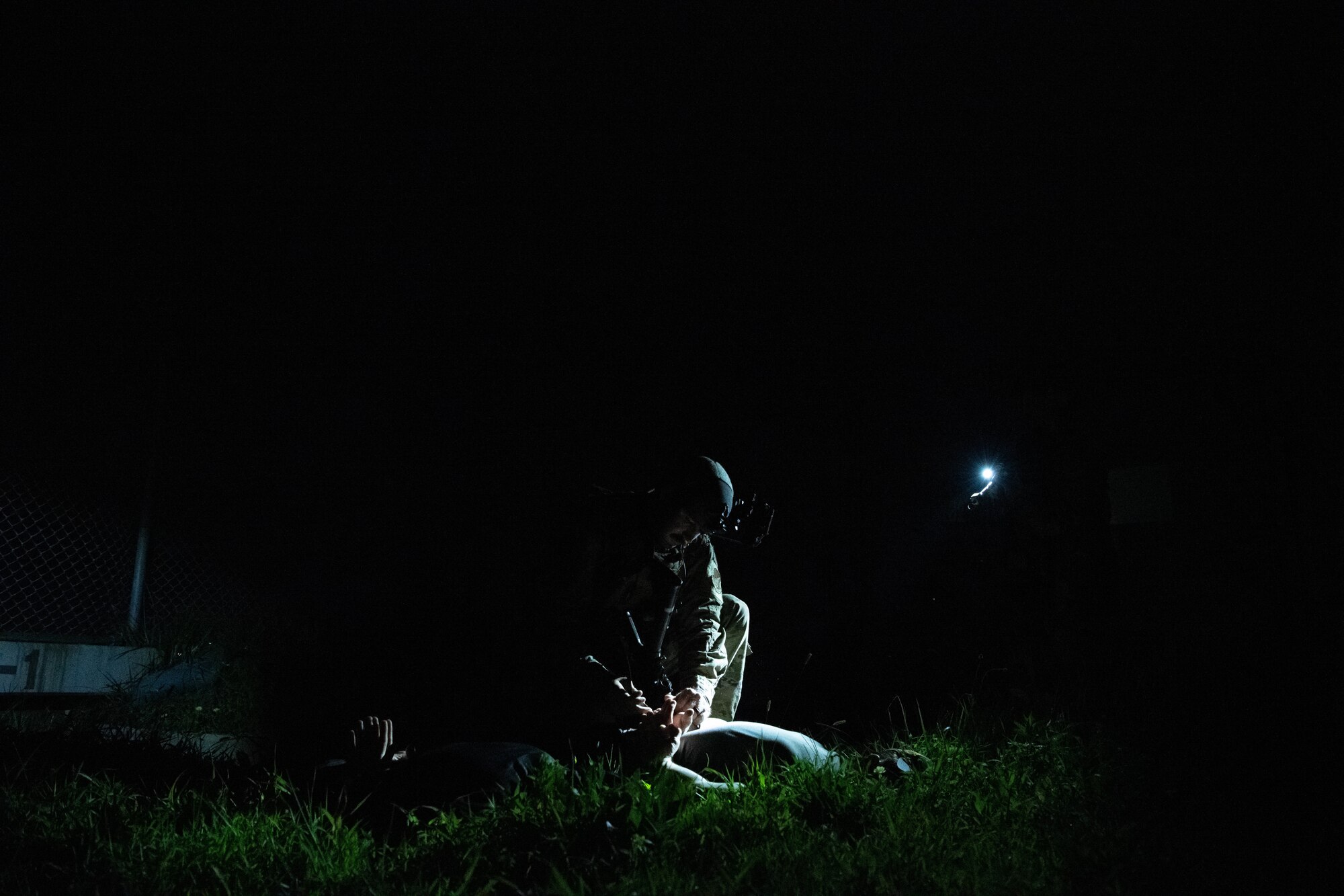 U.S. Air Force Staff Sgt. Christopher Koehler, 8th Security Forces Squadron patrolman, apprehends a simulated suspect during a training event at Kunsan Air Base, Republic of Korea, Sept. 11, 2022. The training ensured all SFS personnel could safely apprehend suspects while remaining vigilant through the night scenario. (U.S. Air Force photo by Staff Sgt. Sadie Colbert)