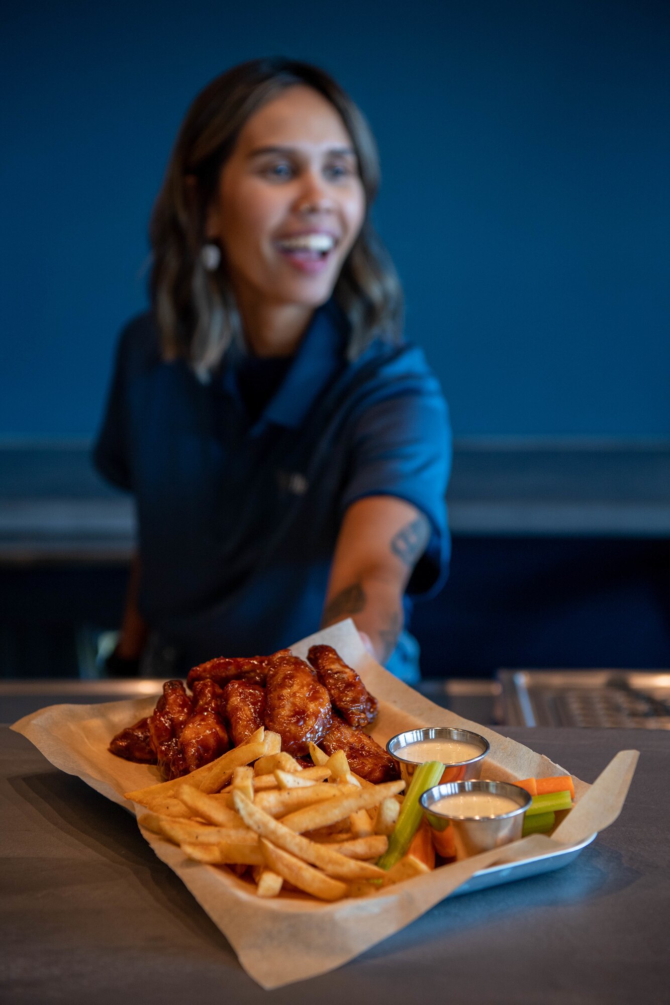 A server from HEROES, a new restaurant in the Kaiserslautern Military Community Center, is ready to serve the community at Ramstein Air Base, Germany, Aug. 12, 2022.