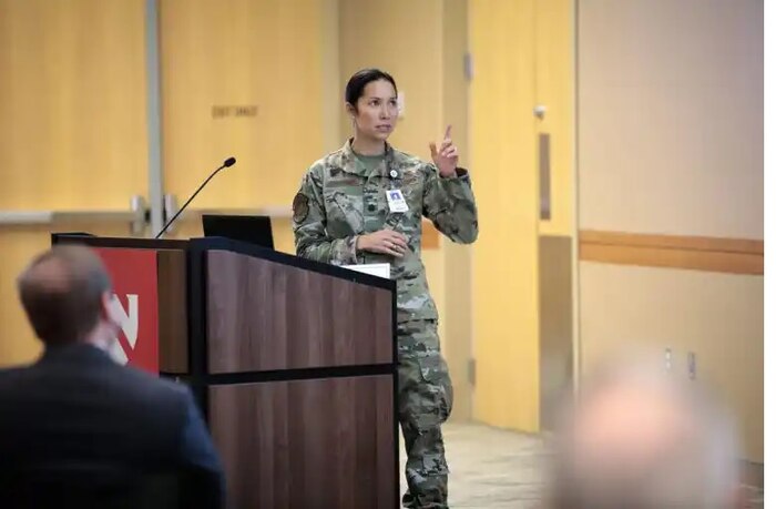 Image of an Airman talking at a podium.