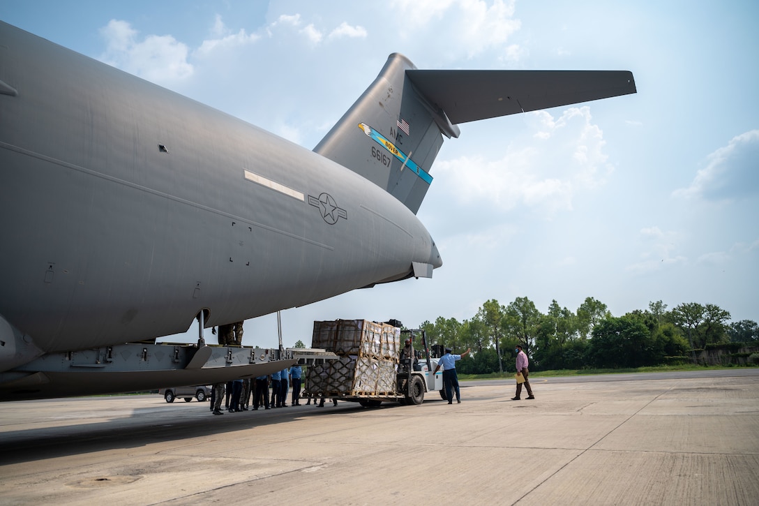 Soldiers unload supplies from a plane.