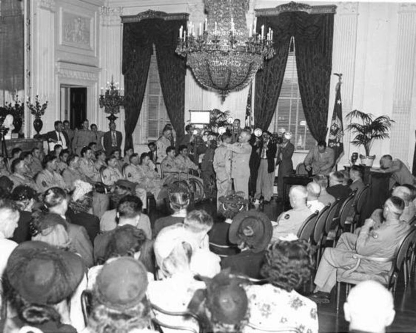 President Harry S. Truman decorates an Army soldier during a Medal of Honor presentation ceremony in the East Room of the White House, Aug. 23, 1945, as other recipients and guests look on. Harry S. Truman Library and Museum photo