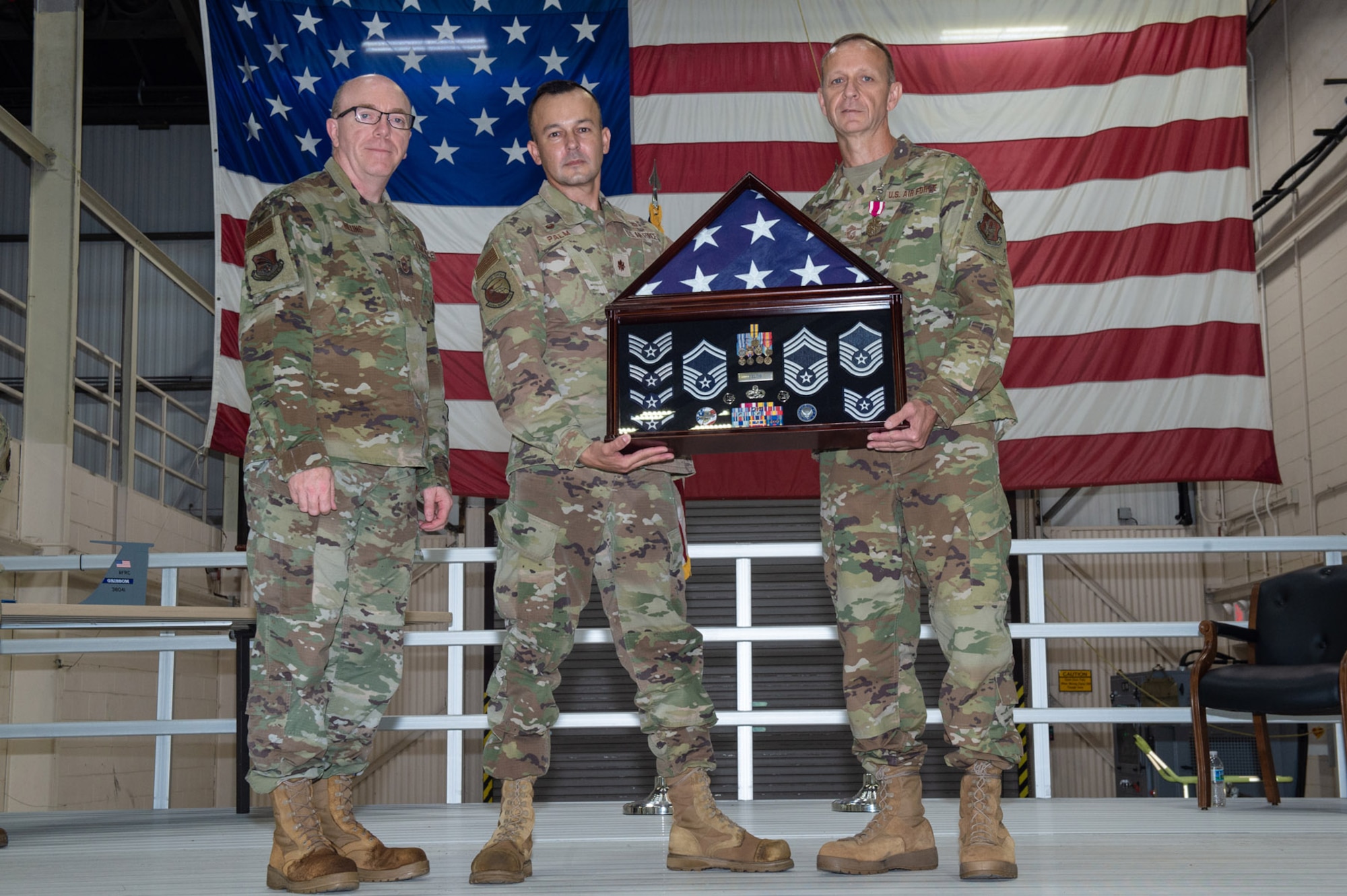 Chief Master Sgt. James Billing, 434th Maintenance Squadron superintendent and Maj. Brad Palm, 434th Maintenance Squadron commander, present Chief Master Sgt. Christopher Feltis, 434th Maintenance Squadron assistant senior enlisted leader, with a shadow box during his retirement ceremony at Grissom Air Reserve Base, Ind. on Sept 11, 2022. Feltis’ retirement was effective Apr. 28, 2022 with more than 32 years of service. (U.S. Air Force photo by Staff Sgt. Alexis Culbert)