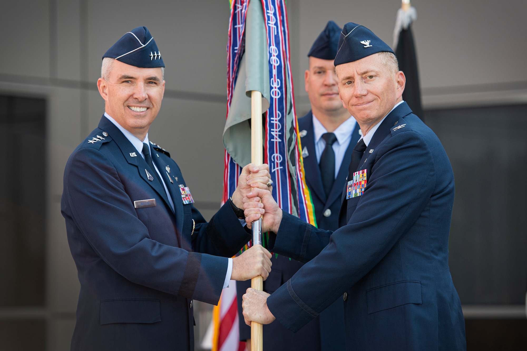Two men passing guidon.