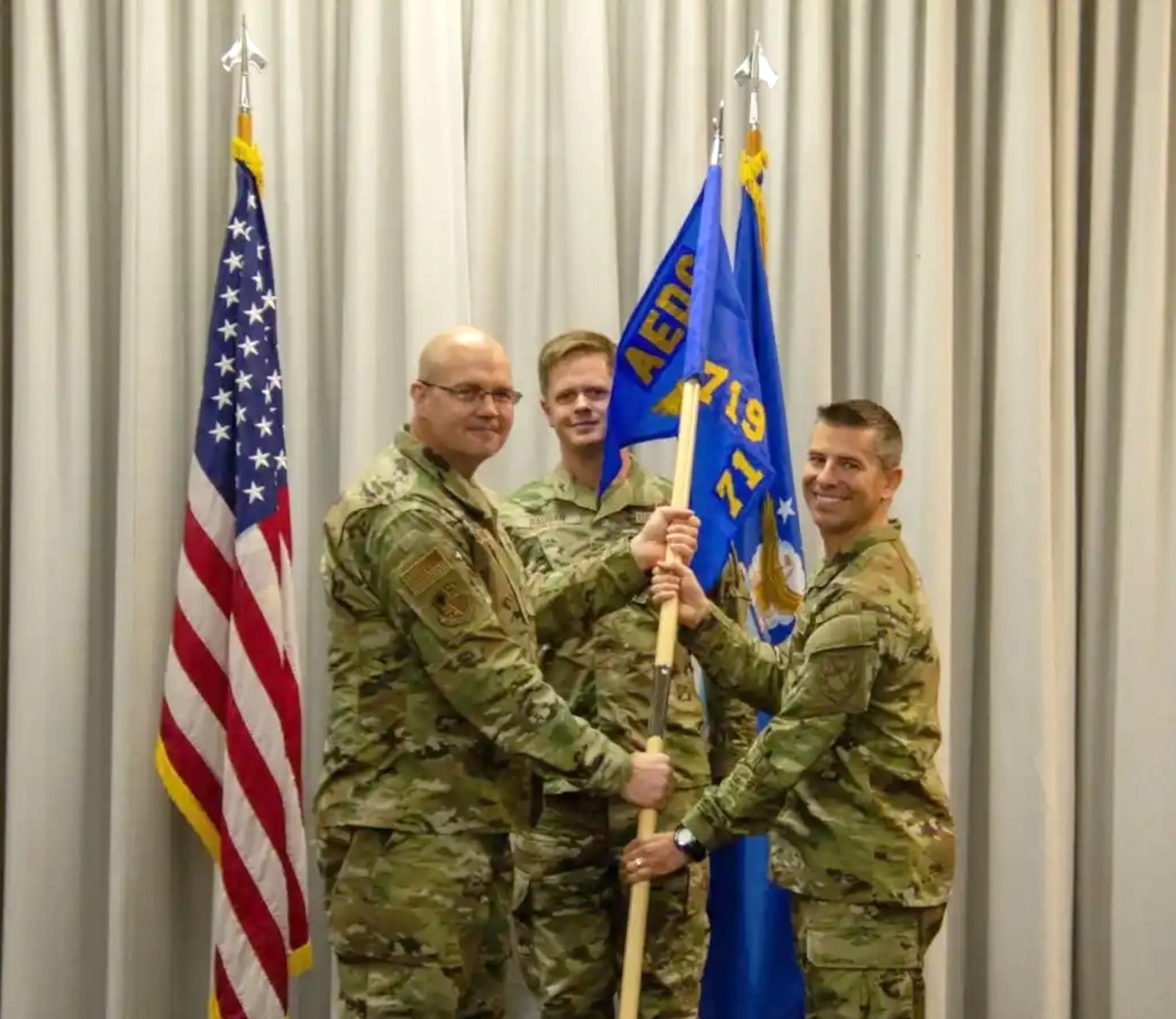 Col. Jason Vap, left, commander, 804th Test Group, passes the 719th Test Squadron guidon to Lt. Col. Jason Heersche, charging him with command of the squadron during a change of command ceremony.