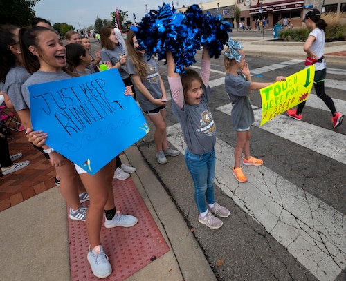 Members of the Miami Valley Dance Center's competition dance team cheer on runners during the 23rd running of the U.S.  Air Force Marathon as they make their way through the Fairborn Skyzone and on to the finish line at Wright-Patterson Air Force Base, Ohio, Sept. 21, 2019. The dance team is based in Fairborn. This year's races attracted more than 12,700 runners representing all 50 states and 15 foreign countries. More than 2,600 volunteers came together to help out at the various events throughout the weekend. The marathon's race courses  span through the adjacent towns around Wright-Patt and serve to celebrate the birthday and the history of the U.S. Air Force in the birthplace of aviation..  (U.S. Air Force photo by Jim Varhegyi)