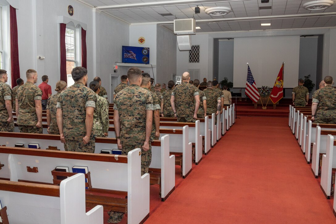 Attendees of the 9/11 remembrance service stand at attention for the playing of Auld Lang Syne, Anchors Away, and the Marines’ Hymn at Memorial Chapel, Marine Corps Air Station Cherry Point, North Carolina, Sept. 9, 2022. The remembrance service was held in honor of those who lost their lives on 9/11. (U.S. Marine Corps photo by Lance Cpl. Lauralle Walker)